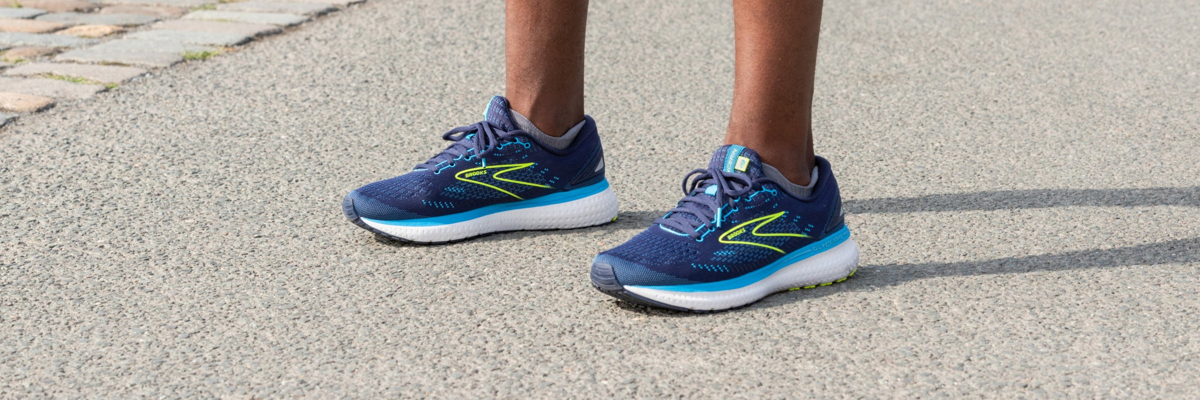 Ein Mann mit dunkelblauen Laufschuhen, nur die Beine sind zu sehen