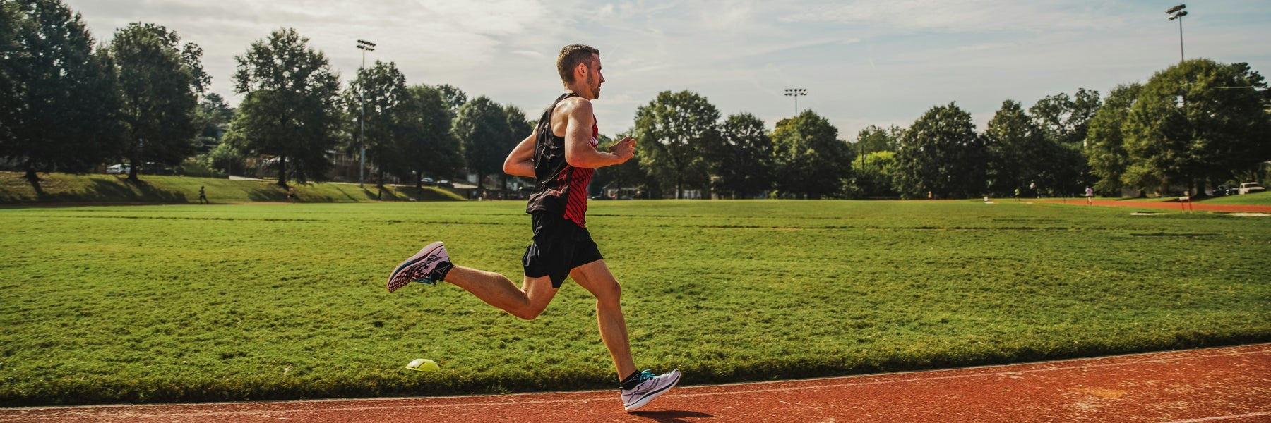 Ein Läufer beim Intervalltraining auf einer Tartanahn, Ansicht von der Seite