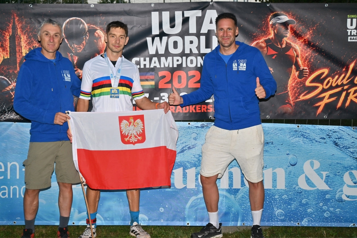 Gewinner Majkel Leśniewski aus Polen posiert nach seinem Triple-Ultra-Triathlon-Erfolg für die Kamera.