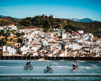 Radfahrer vor der Kulisse eines Bergdorfs im Hinterland von Marbella