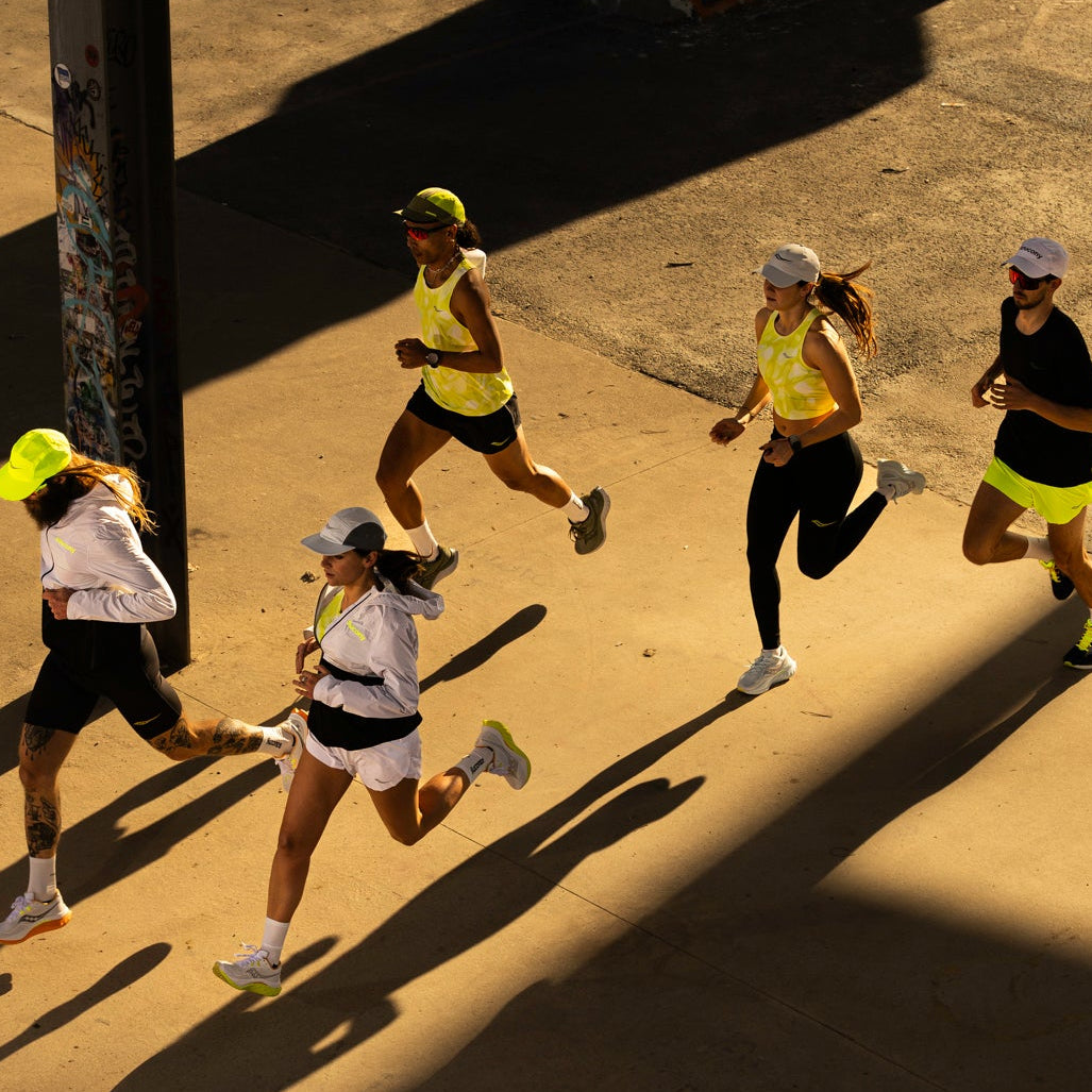 Eine Gruppe von 5 Läuferinnen und Läufern schräg von oben läuft im Sonnenlicht durch einen Säulengang